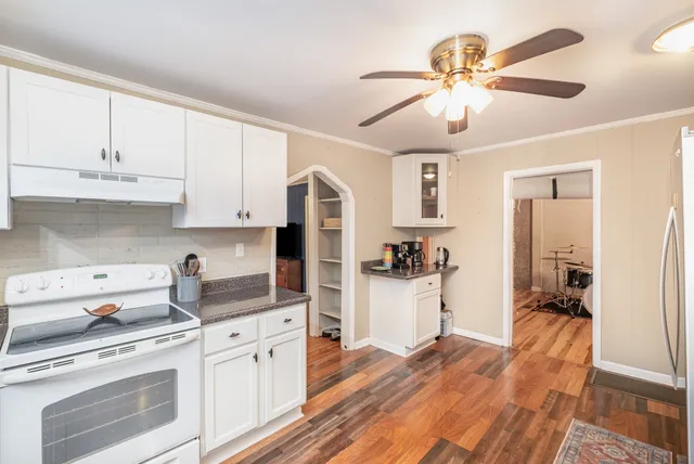 a kitchen with a refrigerator and white cabinets