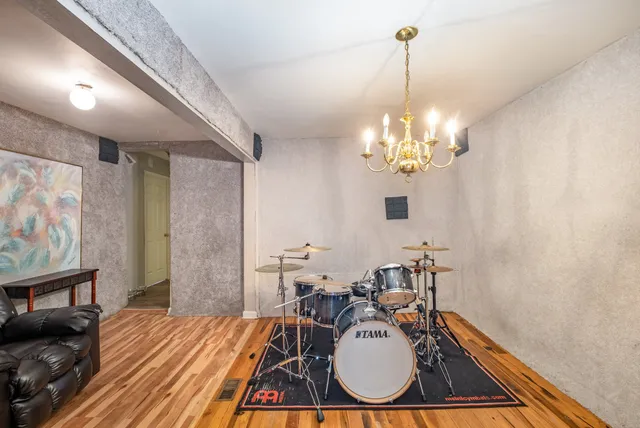 a dining room with wooden floor a chandelier a wooden table and chairs