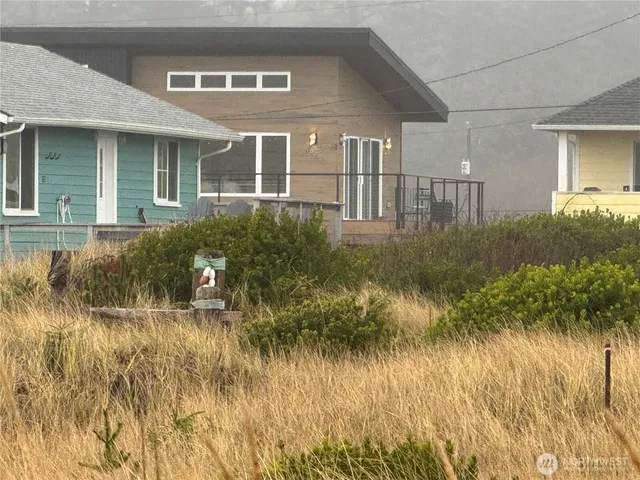a front view of a house with a yard and potted plants