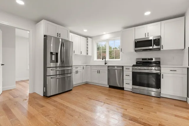 a kitchen with stainless steel appliances a refrigerator sink and microwave