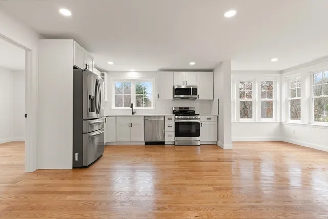 a kitchen with granite countertop a refrigerator and a stove top oven