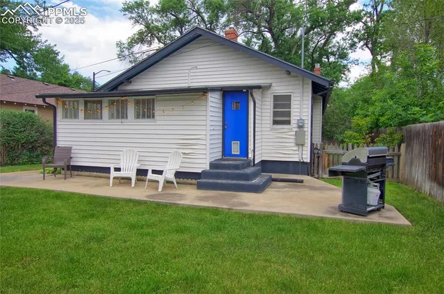 a view of a house with backyard and sitting area