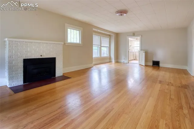 a view of an empty room with window and fire place