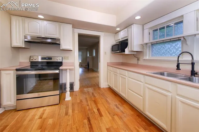 a kitchen with stainless steel appliances granite countertop a stove a sink and a microwave