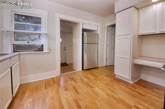 a view of empty room with wooden floor and cabinets