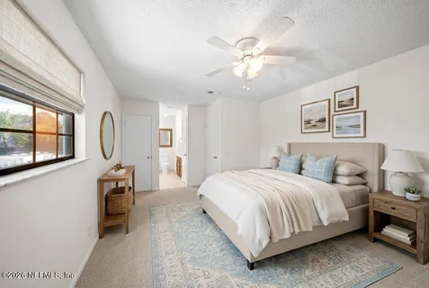 a bedroom with a bed a chandelier and dresser