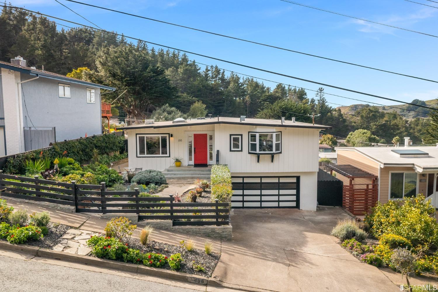 296 Reichling Avenue Pacifica, CA 94044 - Photo 34 of 39 a view of a white house with a small yard and wooden fence