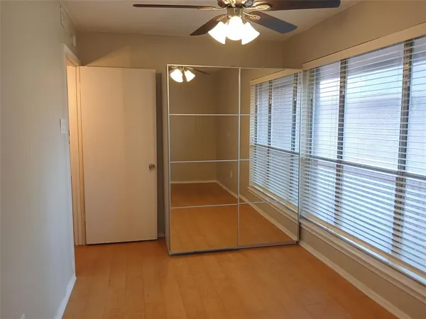 an empty room with a window and a fan