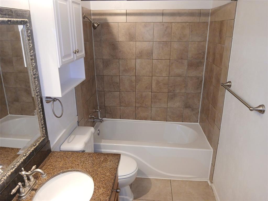 10536 Stone Canyon Road, Unit 216 Dallas, TX 75230 - Photo 17 of 19 a bathroom with a sink a toilet and bathtub