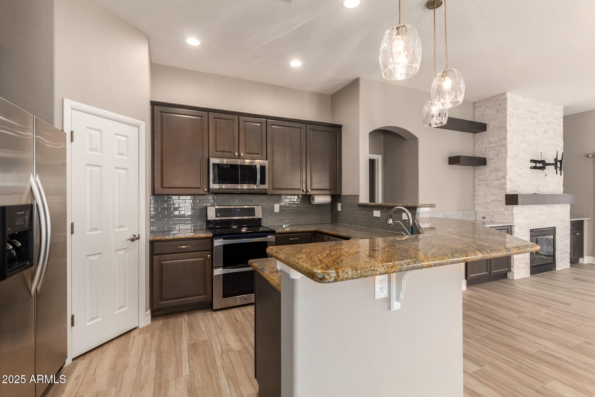 16607 North 50th Way Scottsdale, AZ 85254 - Photo 11 of 24 a kitchen with stainless steel appliances granite countertop a sink a stove top oven a refrigerator and dishwasher with wooden floor