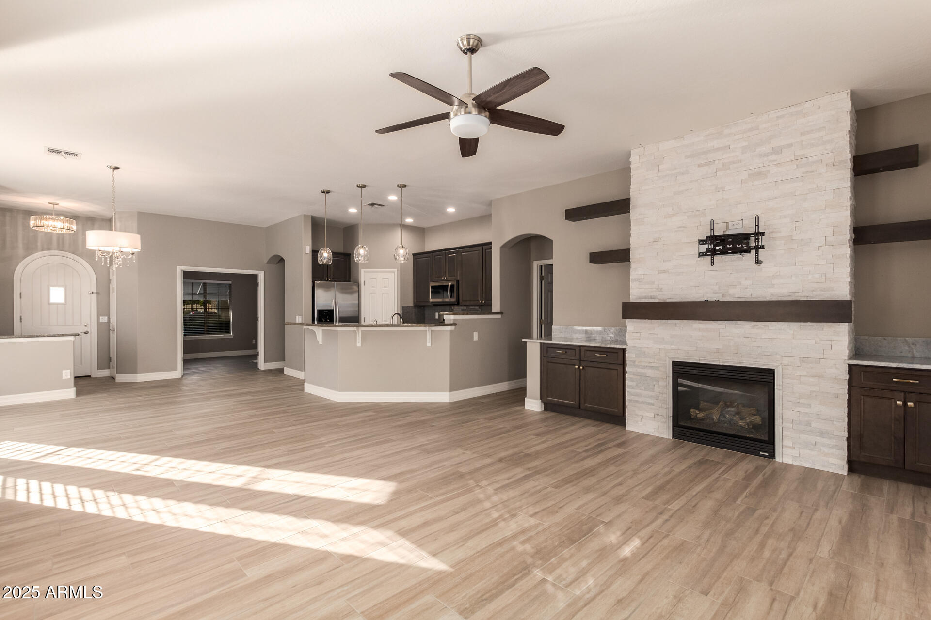16607 North 50th Way Scottsdale, AZ 85254 - Photo 9 of 24 an open kitchen with a fireplace and a ceiling fan