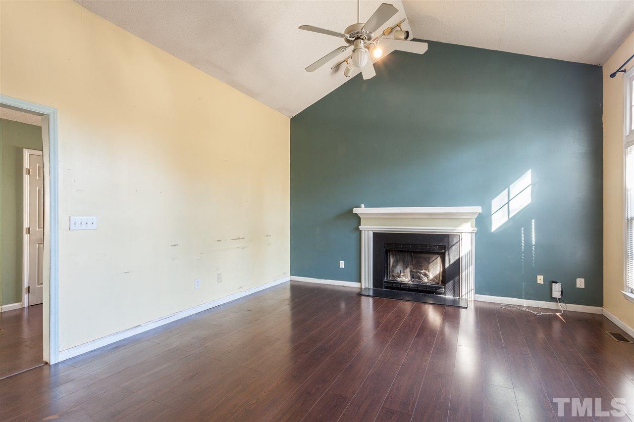 2309 Havering Place Raleigh, NC 27604 - Photo 11 of 23 an empty room with wooden floor fireplace and windows