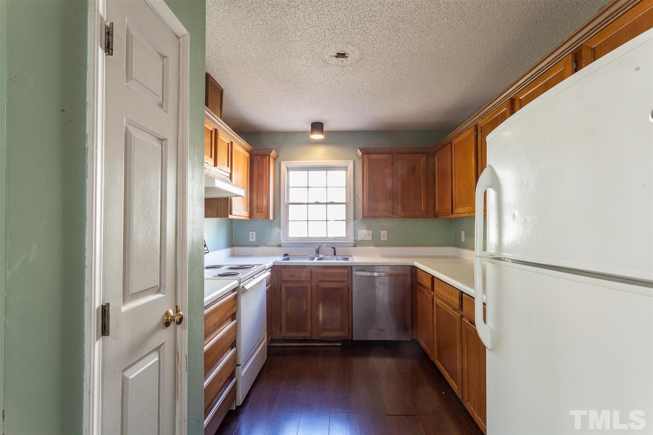 2309 Havering Place Raleigh, NC 27604 - Photo 15 of 23 a kitchen with a sink a window a refrigerator and stainless steel appliances
