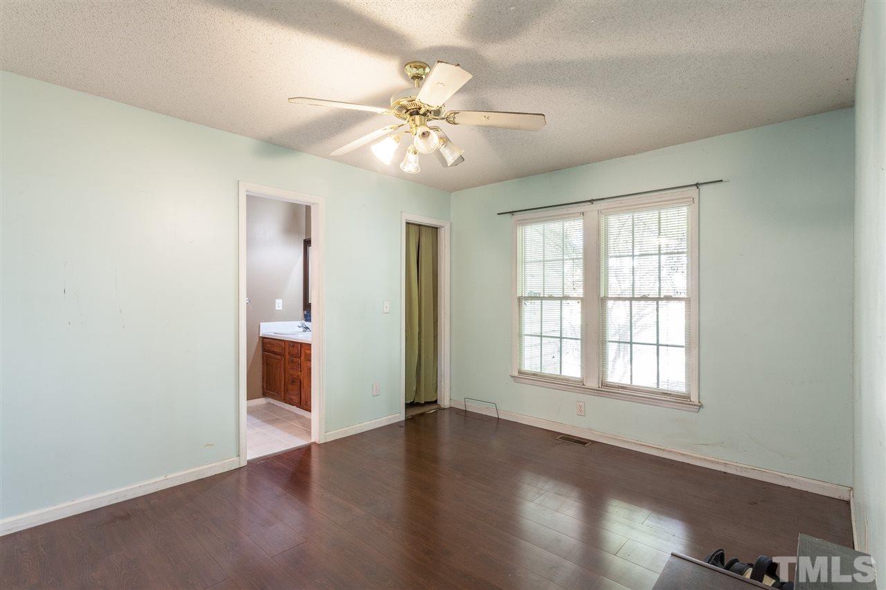 2309 Havering Place Raleigh, NC 27604 - Photo 16 of 23 an empty room with wooden floor chandelier fan and windows