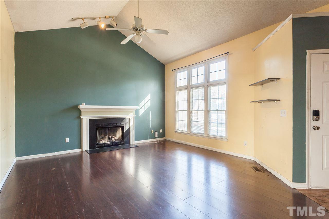 2309 Havering Place Raleigh, NC 27604 - Photo 9 of 23 an empty room with wooden floor fireplace and windows