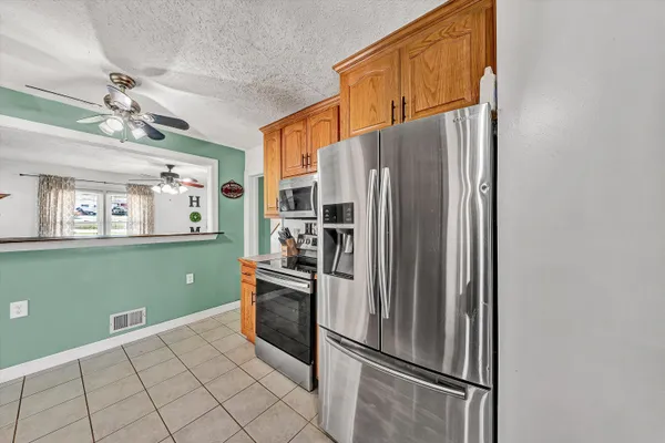 a very nice looking room with a large bed a chandelier and a flat tv screen