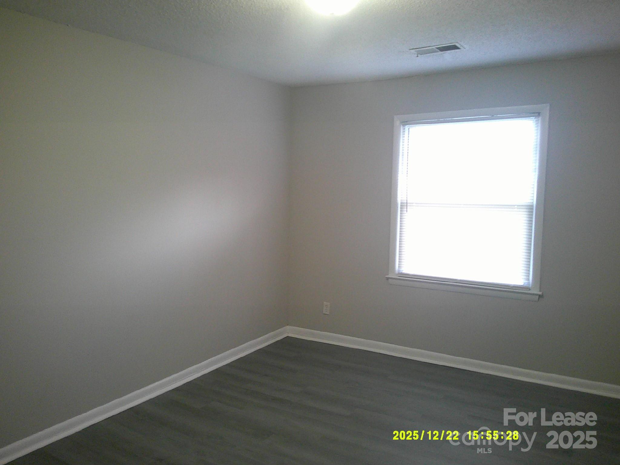 1219 County Home Road Conover, NC 28613 - Photo 4 of 6 an empty room with wooden floor and windows