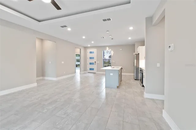 a view of a big room with kitchen and windows