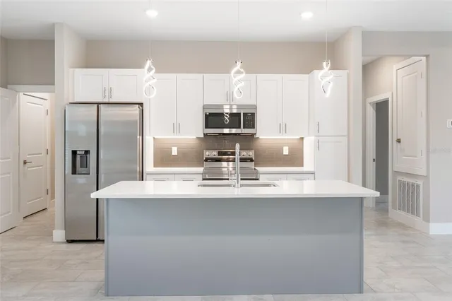 a kitchen with stainless steel appliances a refrigerator sink and microwave