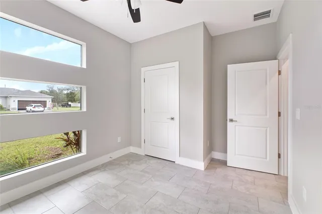 a view of an empty room with a window and fireplace