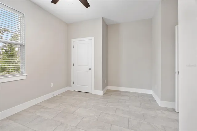 an empty room with fan and windows