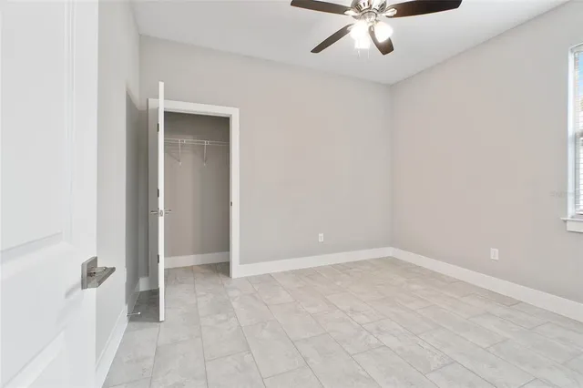 an empty room with windows and fan