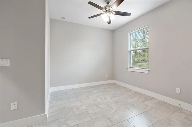 an empty room with a empty space and chandelier fan