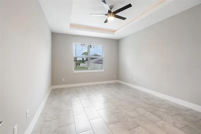 an empty room with a window and a ceiling fan