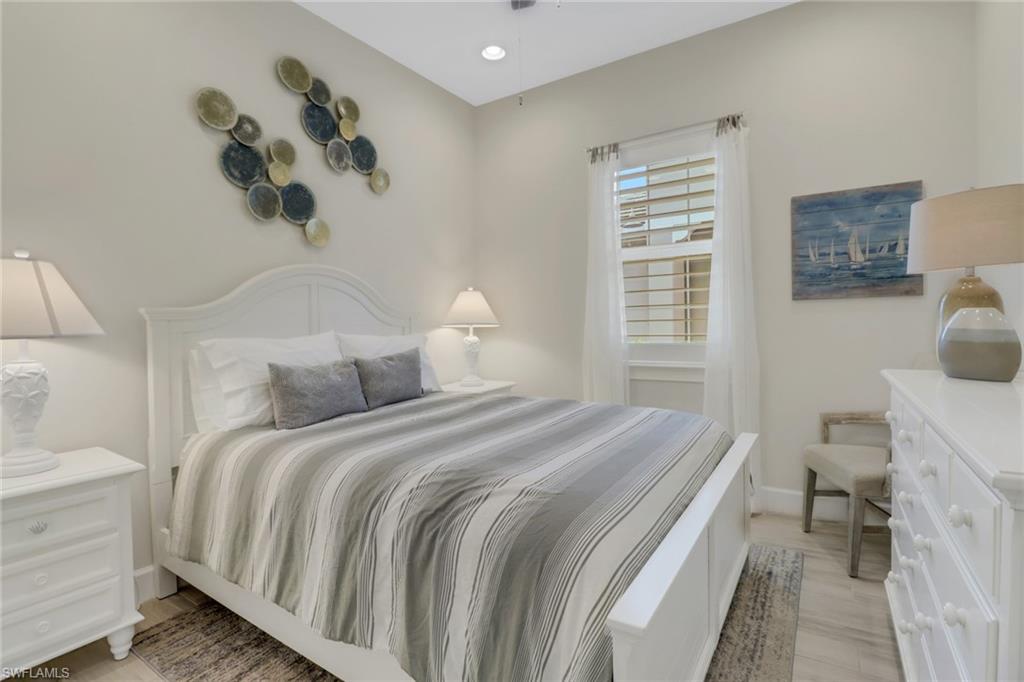 5782 Highbourne Drive Naples, FL 34113 - Photo 14 of 31 a bedroom with a bed and wooden floor