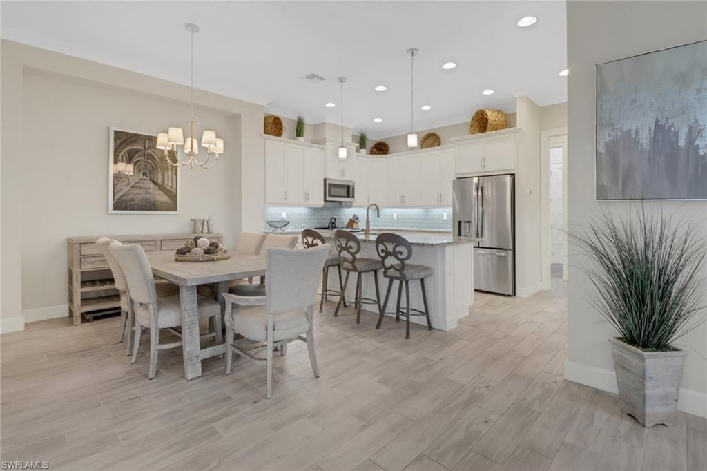 5782 Highbourne Drive Naples, FL 34113 - Photo 4 of 31 a view of a dining room with furniture and wooden floor