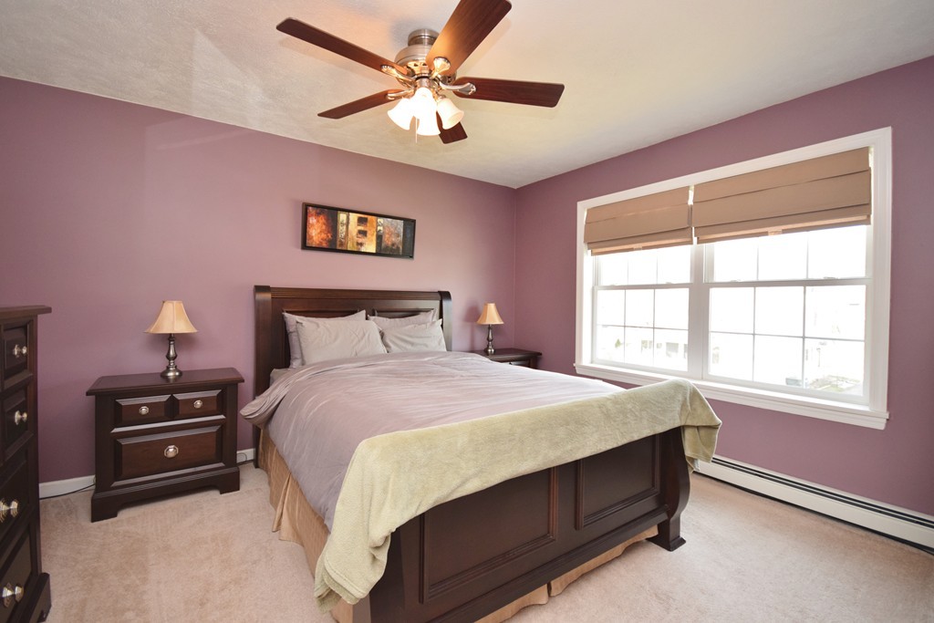 142 Benz Street Springfield, MA 01118 - Photo 7 of 30 a bedroom with a bed next to a window and a chandelier