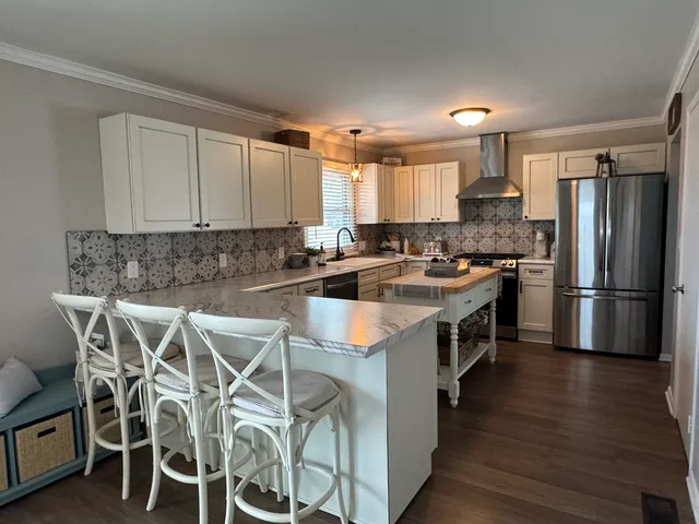 a kitchen with stainless steel appliances a stove a sink refrigerator and a microwave