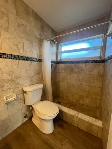 a white toilet sitting next to a shower