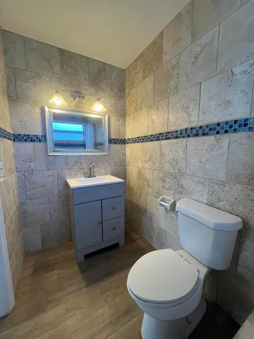 a bathroom with a toilet sink and mirror