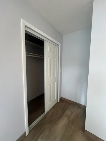an empty room with wooden floor and closet
