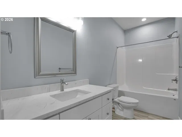 a bathroom with a sink toilet a mirror and shower