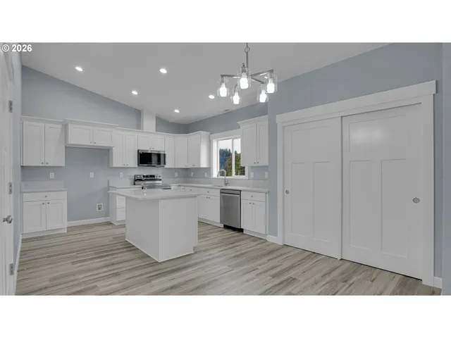 a kitchen with a refrigerator and white cabinets