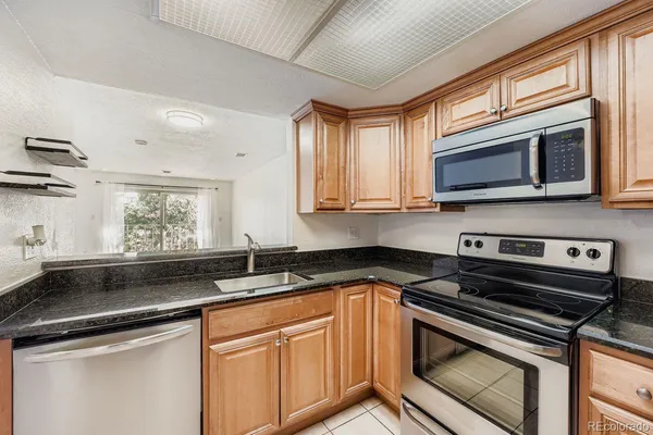 a kitchen with stainless steel appliances granite countertop a sink stove and microwave