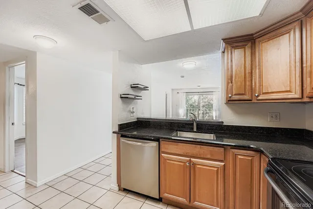 a kitchen with granite countertop white cabinets sink and window