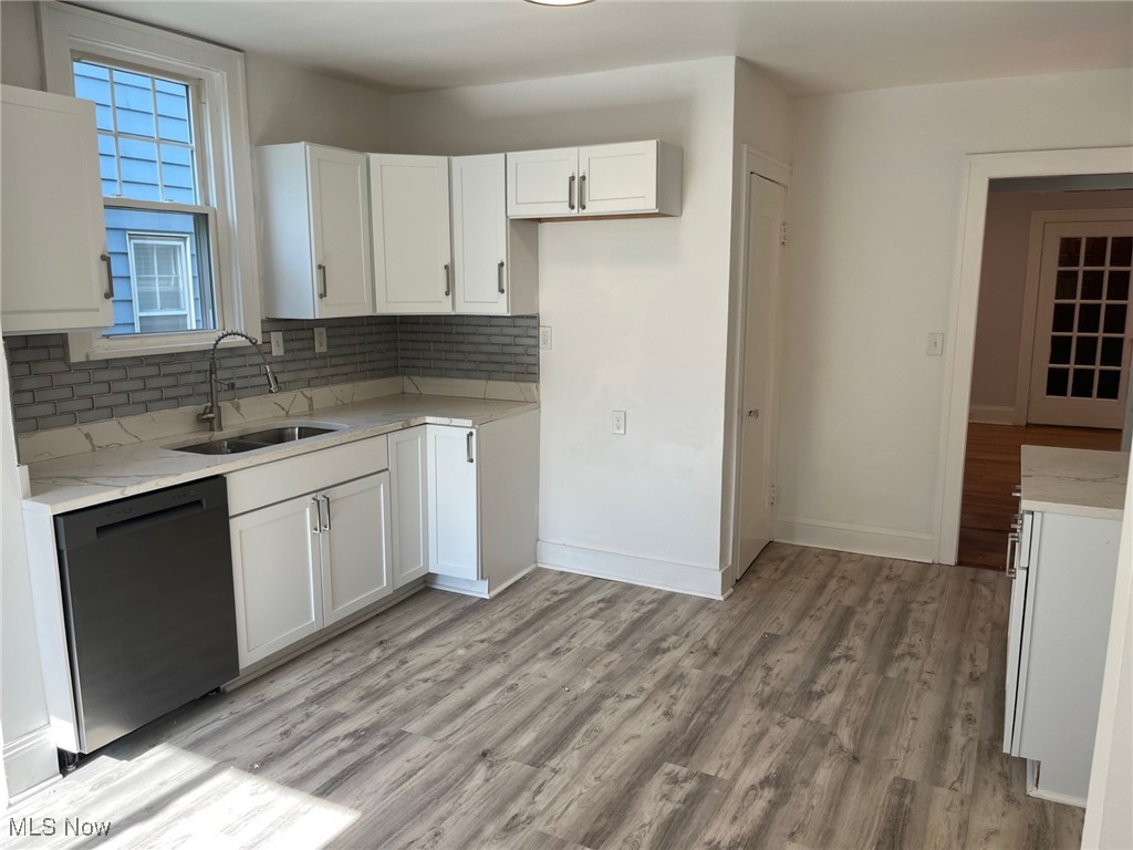 1148 Sylvania Road Cleveland Heights, OH 44121 - Photo 11 of 30 Kitchen with tasteful backsplash, white cabinets, dishwasher, LVT floors, and light stone countertops