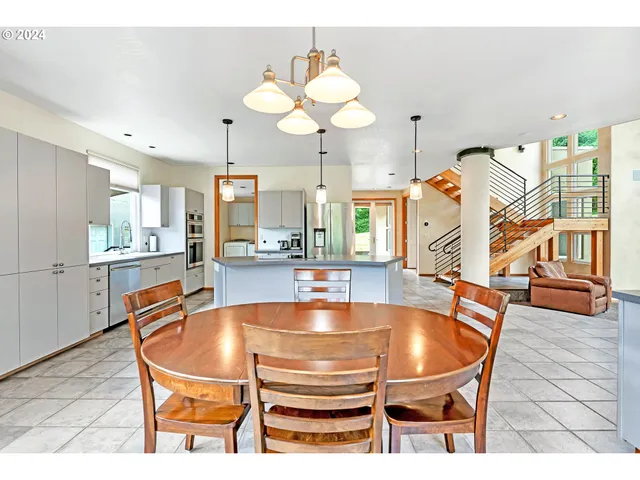 a dining room with stainless steel appliances a table and chairs