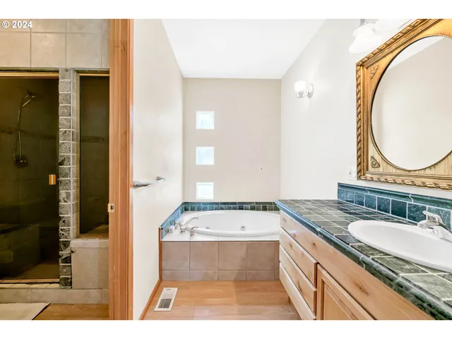 a bathroom with a tub sink and mirror