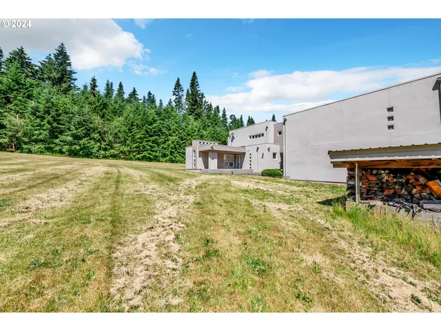 a view of a big room with an ocean and trees in the background