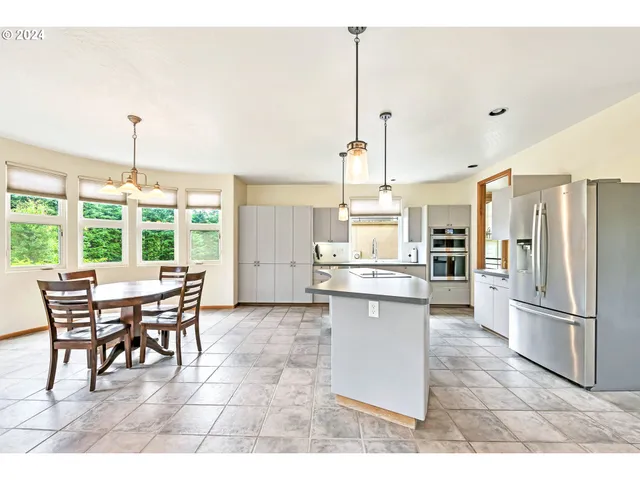 a open kitchen with a table chairs refrigerator and cabinets
