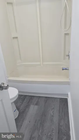 a bathroom with a toilet and a bath tub