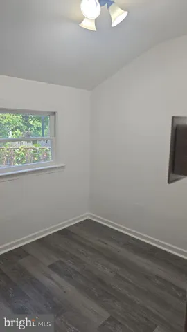 a view of a room that has wooden floor and white walls