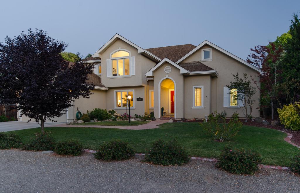 a front view of a house with a yard and potted plants