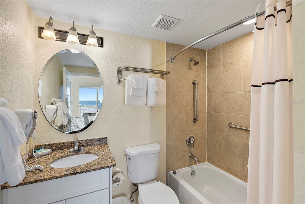 12000 Gulf Boulevard, Unit 501W Treasure Island, FL 33706 - Photo 21 of 36 a bathroom with a granite countertop sink mirror vanity and toilet