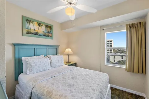 a bedroom with a bed and a flat tv screen on the dresser