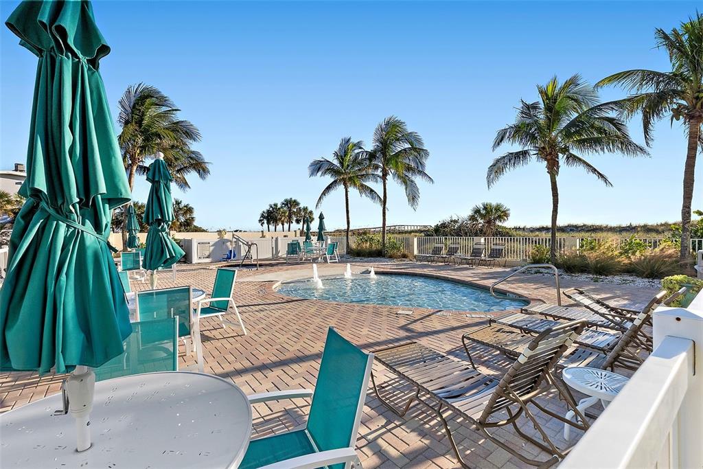 12000 Gulf Boulevard, Unit 501W Treasure Island, FL 33706 - Photo 31 of 36 a view of a swimming pool with a table and chairs